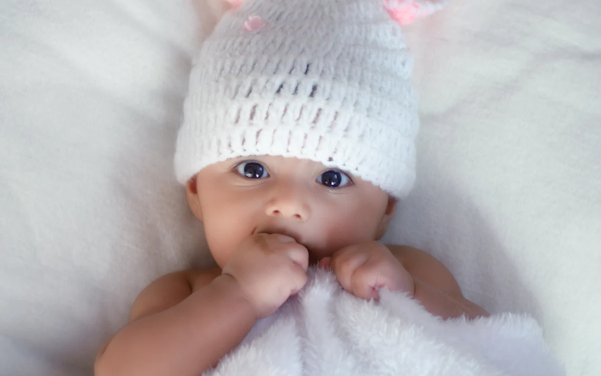 Baby mit weißer Strickmütze.