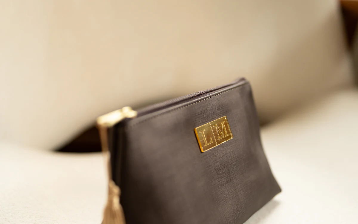 Braune Kosmetiktasche mit goldenem Detail seitlich fotografiert.