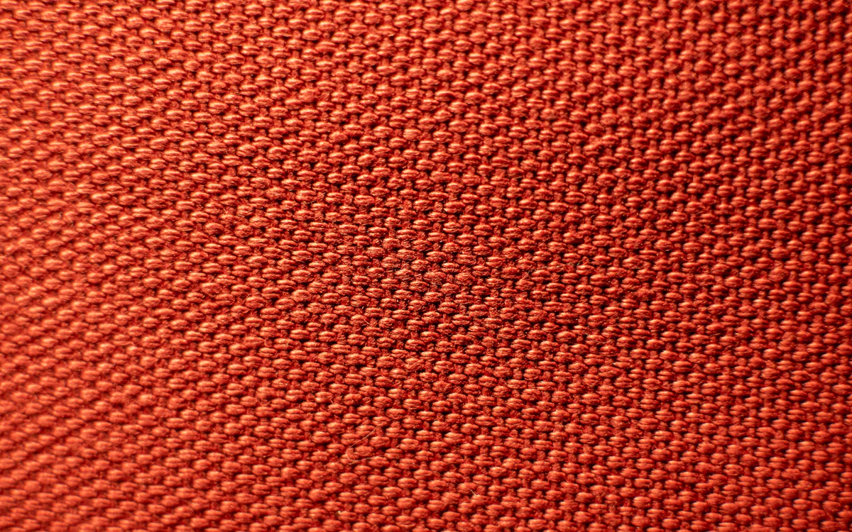 Detail einer rot gefärbten Maschenware mit gleichmäßigen Maschen.
