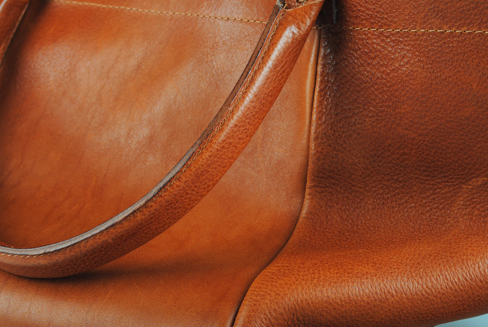 Braune Ledertasche mit langem Schulterriemen in Nahaufnahme.